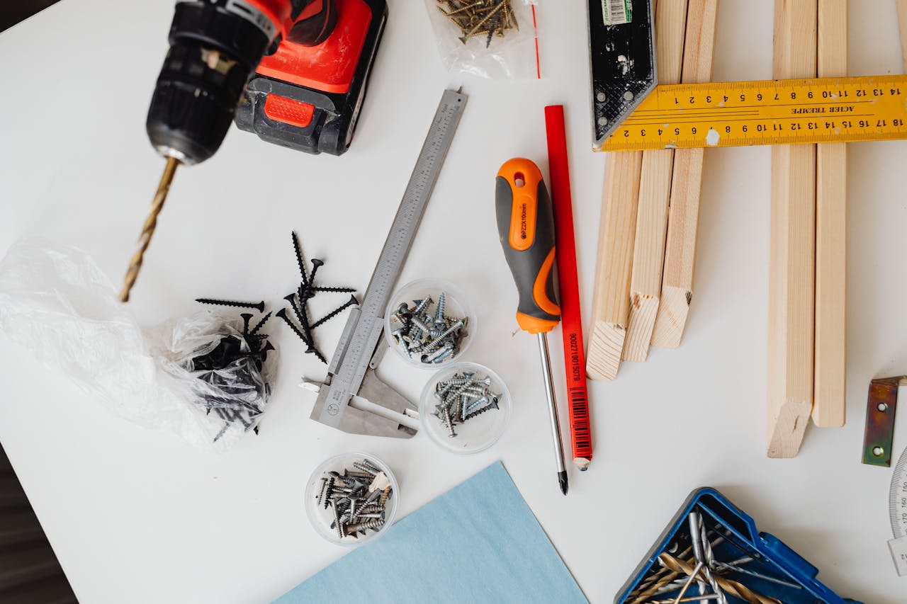 why-choose-us A collection of carpentry tools including drill, caliper, and try square on a white table.